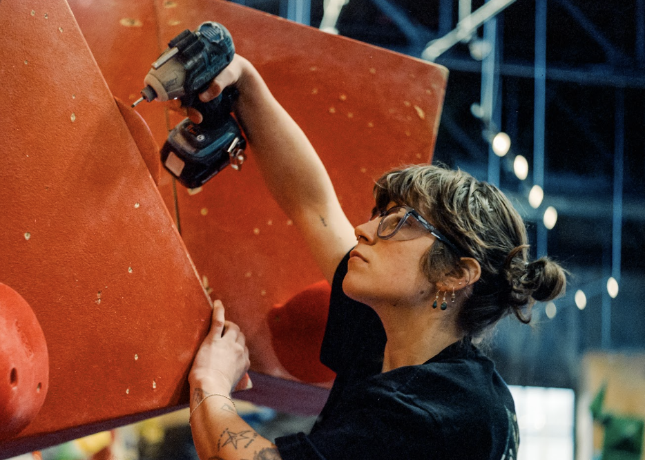 A routesetter drilling the bouldering wall at North Mass