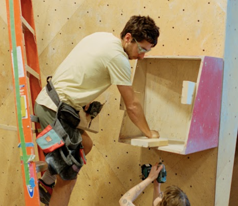 A route setter at north mass on a ladder